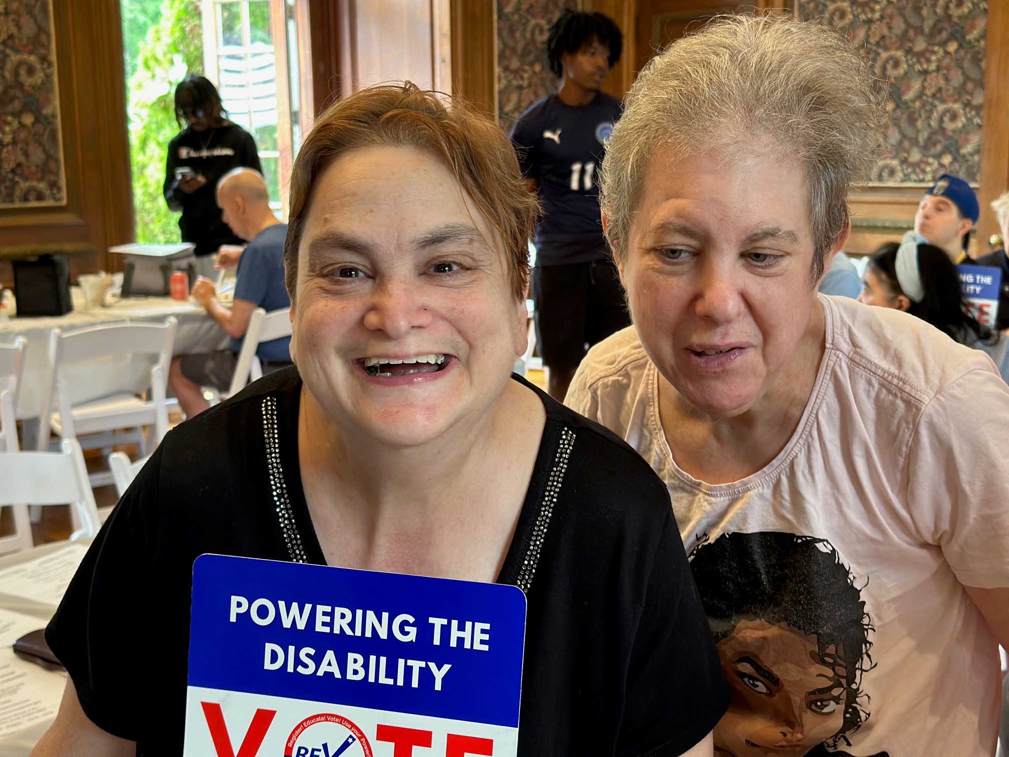 Two people supported pose for a picture at voter registration